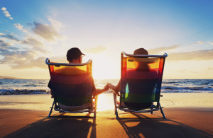 senior couple of old man and woman sitting on the beach watching